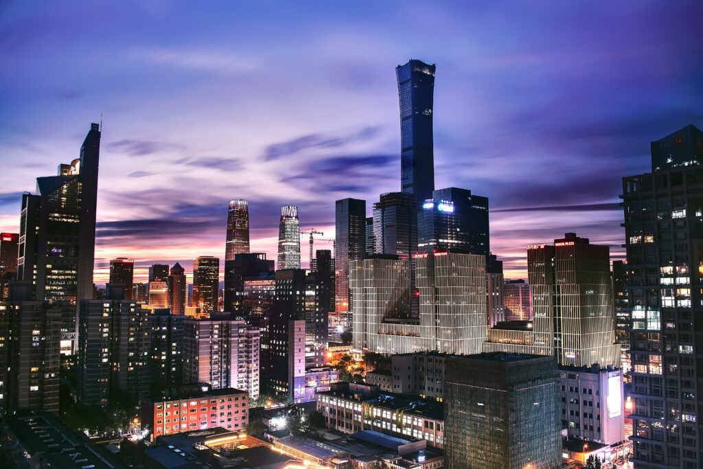A bustling cityscape at dusk with skyscrapers against a purple sunset sky
