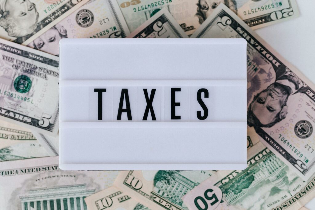 Lightbox with the word 'TAXES' on a background of scattered US dollar bills.