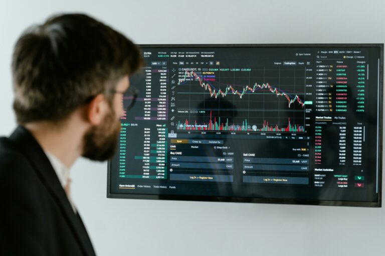 A man analyzing financial data on a large trading screen.